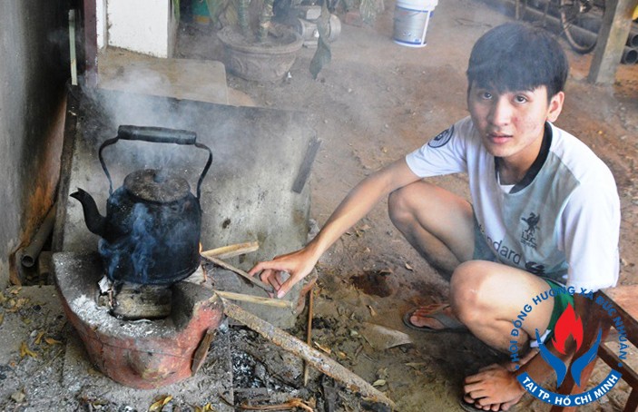 Tùng đun nước bằng bếp củi giúp mẹ. Ảnh: Phạm Linh.